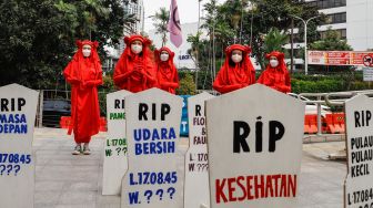 Massa dari berbagai komunitas saat menggelar aksi darurat iklim di Jalan Sudirman, Jakarta Pusat, Jumat (25/3/2022). [Suara.com/Alfian Winanto]