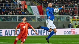 Penyerang Italia Domenico Berardi (kanan) mengincar bola melewati bek Makedonia Utara Ezgjan Alioski saat pertandingan sepak bola play-off kualifikasi Piala Dunia 2022 antara Italia dan Makedonia Utara di stadion Renzo-Barbera, Palermo, Italia, Kamis (24/3/2022). [Alberto PIZZOLI / AFP]