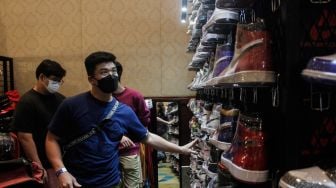 Pengunjung memilih koleksi sepatu sneaker saat Event Jakarta Sneaker Day (JSD) di Mall Senayan City, Jakarta Pusat, Jumat (25/3/2022). [Suara.com/Septian]