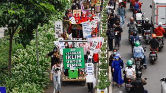 Massa dari berbagai komunitas saat menggelar aksi darurat iklim di Jalan Sudirman, Jakarta Pusat, Jumat (25/3/2022). [Suara.com/Alfian Winanto]