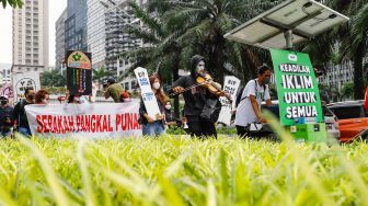 Massa dari berbagai komunitas saat menggelar aksi darurat iklim di Jalan Sudirman, Jakarta Pusat, Jumat (25/3/2022). [Suara.com/Alfian Winanto]