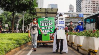 Massa dari berbagai komunitas saat menggelar aksi darurat iklim di Jalan Sudirman, Jakarta Pusat, Jumat (25/3/2022). [Suara.com/Alfian Winanto]