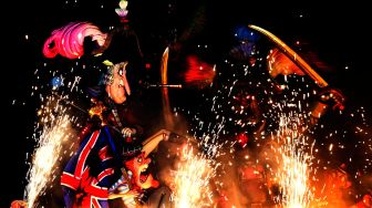 Boneka-boneka dari karton yang biasa disebut 'Ninot' dan 'Falla' dibakar saat Festival Fallas di Valencia, Spanyol, Sabtu (19/3/2022). [Jose Jordan / AFP] 