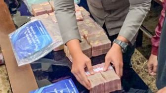 Barang bukti uang tunai milik Tersangka Indra Kesuma alias Indra Kenz ditampilkan saat rilis kasus dugaan penipuan berkedok trading binary option, Binomo di Bareskrim Mabes Polri, Jakarta Selatan, Jumat (25/3/2022). [Suara.com/Adiyoga Priyambodo]