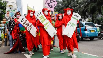 Massa dari berbagai komunitas saat menggelar aksi darurat iklim di Jalan Sudirman, Jakarta Pusat, Jumat (25/3/2022). [Suara.com/Alfian Winanto]