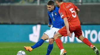 Gelandang Italia Marco Verratti (kiri) menantang gelandang Makedonia Utara Arijan Ademi saat pertandingan sepak bola play-off kualifikasi Piala Dunia 2022 antara Italia dan Makedonia Utara di stadion Renzo-Barbera, Palermo, Italia, Kamis (24/3/2022). [Alberto PIZZOLI / AFP]