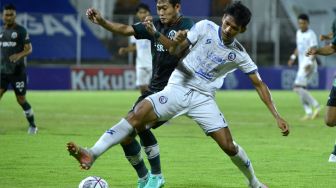 Pesepak bola Arema FC Ryan Kurnia (kanan) berebut bola dengan pesepak bola Persikabo 1973 Ahmad Birrul Walidain (kiri) saat pertandingan Liga 1 di Stadion Kompyang Sujana, Denpasar, Bali, Kamis (24/3/2022). [ANTARA FOTO/Fikri Yusuf/hp]