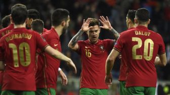 Para pemain Portugal melakukan selebrasi setelah pemain depan Portugal Diogo Jota mencetak gol saat pertandingan sepak bola play-off kualifikasi Piala Dunia 2022 antara Portugal dan Turki di stadion Dragao, Porto, Portugal, Kamis (24/3/2022). [MIGUEL RIOPA / AFP]