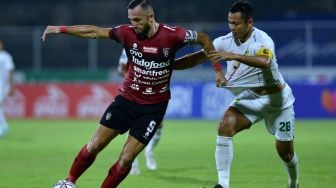 Pesepak bola Bali United Ilija Spasojevic (kiri) berebut bola dengan pesepak bola Persebaya Surabaya Arif Satria (kanan) saat pertandingan Liga 1 di Stadion I Gusti Ngurah Rai, Denpasar, Bali, Jumat (25/3/2022). [ANTARA FOTO/Fikri Yusuf/rwa]
