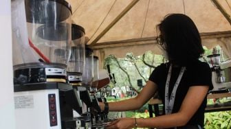 Pengunjung melihat-lihat berbagai jenis kopi saat Event Jakarta Coffee Experience 2022 di Grange Park Cipete, Jakarta Selatan, Jumat (25/3/2022). [Suara.com/Septian]