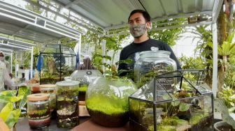 Suasana pengunjung piknik di halaman Kebun Raya Bogor, Bogor ,jawa Barat, Minggu (27/3/2022).  [Suara.com/Septian]