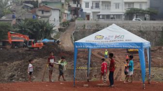 Sejumlah anak bermain di dekat lahan yang akan dijadikan Waduk Brigif, Jagakarsa, Jakarta, Minggu (27/3/2022). [Suara.com/Angga Budhiyanto]