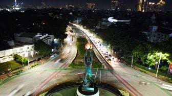 Lampu Patung Pemuda Membangun sebelum dipadamkan untuk memperingati Earth Hour di Kawasan Senayan, Jakarta Selatan, Sabtu (26/3/2022). [Suara.com/Alfian Winanto]