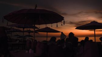 Pengunjung menikmati pemandangan matahari terbenam di pantai Tanjung Bias, Desa Senteluk, Kecamatan Batulayar, Lombok Barat, NTB, Sabtu (26/3/2022). ANTARA FOTO/Ahmad Subaidi