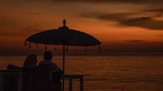 Pengunjung menikmati pemandangan matahari terbenam di pantai Tanjung Bias, Desa Senteluk, Kecamatan Batulayar, Lombok Barat, NTB, Sabtu (26/3/2022). ANTARA FOTO/Ahmad Subaidi