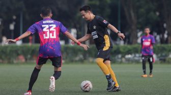 Pemain Selebritis FC Delon Thamrin membawa bola saat mengikuti sesi latihan di Lapangan ABC, Kompleks Gelora Bung Karno, Jakarta, Senin (28/3/2022). [Suara.com/Angga Budhiyanto]