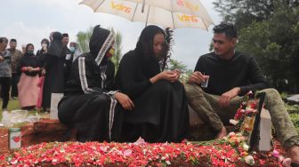 Kalina Oktarani bersama keluarga berdoa di samping makam sang ibunda Erlan Wardhania di TPU Taman Abadi, Ciputat, Tangerang Selatan, Banten, Senin (28/3/2022). [Suara.com/Angga Budhiyanto]