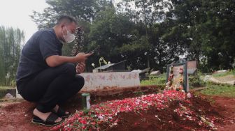 Presenter Vicky Prasetyo berdoa di samping makam ibunda Kalina Oktarani, Erlan Wardhania di TPU Taman Abadi, Ciputat, Tangerang Selatan, Banten, Senin (28/3/2022). [Suara.com/Angga Budhiyanto]