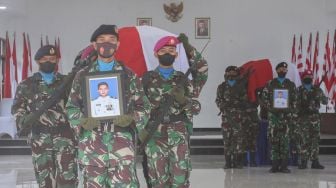 Prajurit TNI AL mengangkat peti jenazah prajurit Marinir TNI AL Lettu Marinir (Anumerta) Muhammad Ikbal saat upacara pelepasan jenazah di Timika, Papua, Senin (28/3/2022). . ANTARA FOTO /Sevianto Pakiding