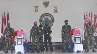 Prajurit TNI AL berada di dekat dua peti jenazah prajurit Marinir yang gugur saat upacara pelepasan jenazah di Timika, Papua, Senin (28/3/2022).  ANTARA FOTO /Sevianto Pakiding
