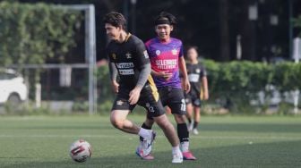 Pemain Selebritis FC Iko Uwais melewati lawan saat mengikuti sesi latihan di Lapangan ABC, Kompleks Gelora Bung Karno, Jakarta, Senin (28/3/2022). [Suara.com/Angga Budhiyanto]