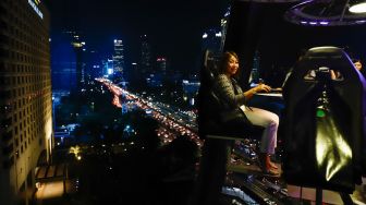 Pengunjung menikmati makan malam diatas ketinggian 50 meter di restoran Lounge In The Sky Indonesia di Setiabudi, Jakarta Selatan, Selasa (29/3/2022). [Suara.com/Alfian Winanto]