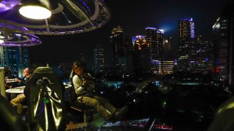 Pengunjung menikmati makan malam diatas ketinggian 50 meter di restoran Lounge In The Sky Indonesia di Setiabudi, Jakarta Selatan, Selasa (29/3/2022). [Suara.com/Alfian Winanto]