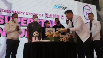 Raffi Ahmad (kedua kanan) memotong tumpeng saat acara "Superstar Announcement RANS Cilegon FC" di kantor Prestige Motorcars, Pluit, Jakarta, Selasa (29/3/2022). [Suara.com/Angga Budhiyanto]