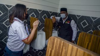 Gubernur Jawa Barat Ridwan Kamil (kanan) meninjau toilet komunal daur ulang di Kelurahan Pasirluyu, Bandung, Jawa Barat, Selasa (29/3/2022).  ANTARA FOTO/Novrian Arbi