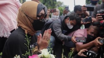 Mantan Politikus Angelina Sondakh berziarah ke makam suaminya, Adjie Massaid di TPU Jeruk Purut, Jakarta, Rabu (30/3/2022). [Suara.com/Angga Budhiyanto]