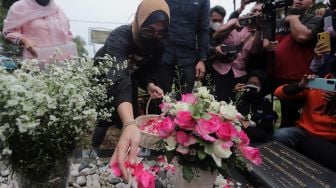 Mantan Politikus Angelina Sondakh menaburkan bunga saat berziarah ke makam suaminya, Adjie Massaid di TPU Jeruk Purut, Jakarta, Rabu (30/3/2022). [Suara.com/Angga Budhiyanto]