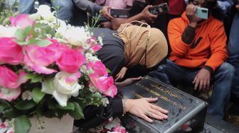 Mantan Politikus Angelina Sondakh berziarah ke makam suaminya, Adjie Massaid di TPU Jeruk Purut, Jakarta, Rabu (30/3/2022). [Suara.com/Angga Budhiyanto]