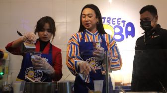 Fujianti Utami atau Fuji An (kiri) meracik minuman boba saat acara launching menu kolaborasi Fuji X Street Boba di Street Boba Ampera, Jakarta, Kamis (31/3/2022). [Suara.com/Angga Budhiyanto]