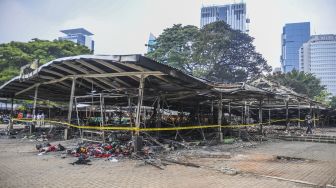 Pedagang melihat kondisi puing-puing kios pascakebakaran di kawasan Monas, Jakarta, Kamis (31/3/2022).  [ANTARA FOTO/Galih Pradipta]