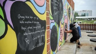 Warga mencoret dinding dengan menggunakan kapur saat peresmian Ruang Curhat di Pasteur, Bandung, Jawa Barat, Jumat (1/4/2022).  ANTARA FOTO/Raisan Al Faris