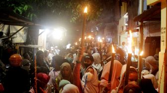 Sejumlah warga dan anak-anak mengikuti pawai obor di Jalan Menteng Jaya, Jakarta Pusat, Kamis (31/3/2022).  [Suara.com/Oke Atmaja]
