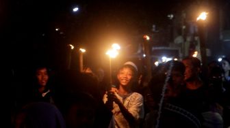 Sejumlah warga dan anak-anak mengikuti pawai obor di Jalan Menteng Jaya, Jakarta Pusat, Kamis (31/3/2022).  [Suara.com/Oke Atmaja]
