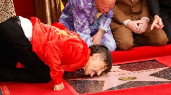 Vokalis Band Red Hot Chili Peppers Anthony Kiedis (merah) berpose saat acara peletakan emblem bintang Red Hot Chili Peppers di Hollywood Walk of Fame di Los Angeles, California, Amerika Serikat, Kamis (31/3/2022). [Michael Tran / AFP]
