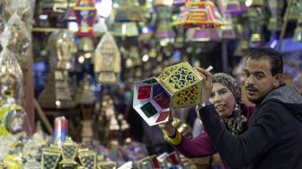 Warga Mesir berbelanja lentera Ramadhan di sebuah pasar di distrik Sayyida Zeinab, Kairo, Mesir, Rabu (30/3/2022). [Khaled DESOUKI / AFP]