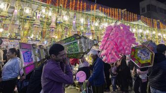 Warga Mesir membeli lentera Ramadhan untuk menghiasi rumah mereka di sebuah pasar di distrik Sayyida Zeinab, Kairo, Mesir, Rabu (30/3/2022). [Khaled DESOUKI / AFP]