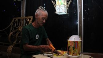 Seniman Pontianak Harry Eko Rifanto membuat lampion dari bungkusan mie instant di Kian Gallery Mustang di Gang Belibis, Pontianak, Kalimantan Barat, Jumat (1/4/2022) malam. [ANTARA FOTO/Jessica Helena Wuysang/foc]