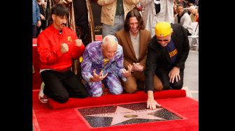 Para personil Band Red hot Chili Pepper Anthony Kiedis, Flea, John Frusciante and Chad Smith saat menghadiri acara peletakan emblem bintang Red Hot Chili Peppers di Hollywood Walk of Fame di Los Angeles, California, Amerika Serikat, Kamis (31/3/2022). [Michael Tran / AFP]