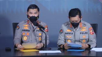 Kepala Biro Penerangan Masyarakat (Karopenmas) Brigjen Pol Ahmad Ramadhani didampingi Kepala Bagian Penerangan Umum (Kapagpenum) Kombes Pol Gatot Repli Handoko menunjukkan berkas penetapan Daftar Pencarian Orang (DPO) atas nama Putra Wibowo saat konferensi pers di Gedung Divisi Humas Polri, Jakarta Selatan, Senin (4/4/2022). [Suara.com/Alfian Winanto]