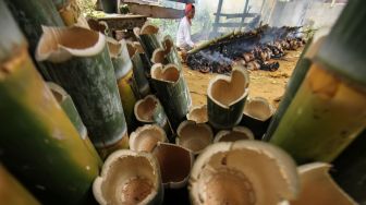 Pembuat leumang membakar leumang bambu di Desa Blang Rayeuk, Lhokseumawe, Aceh, Minggu (3/4/2022). [ANTARA FOTO/Rahmad/YU]