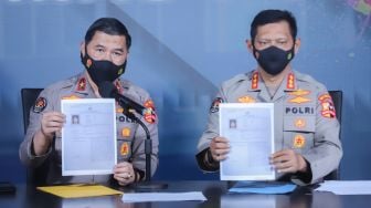 Kepala Biro Penerangan Masyarakat (Karopenmas) Brigjen Pol Ahmad Ramadhani didampingi Kepala Bagian Penerangan Umum (Kapagpenum) Kombes Pol Gatot Repli Handoko menunjukkan berkas penetapan Daftar Pencarian Orang (DPO) atas nama Putra Wibowo saat konferensi pers di Gedung Divisi Humas Polri, Jakarta Selatan, Senin (4/4/2022). [Suara.com/Alfian Winanto]