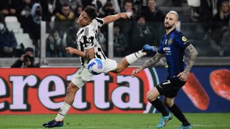 Pemain depan Juventus Paulo Dybala (kiri) dan pemain tengah Inter Milan Marcelo Brozovic mengejar bola saat pertandingan sepak bola Serie A Italia antara Juventus dan Inter di Stadion Allianz, Turin, Italia, Minggu (3/4/2022). [Filippo MONTEFORTE / AFP] 