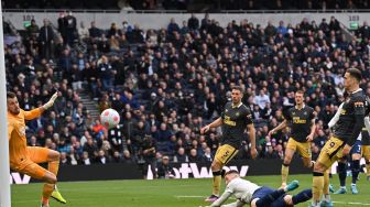 Bek Tottenham Hotspur Matt Doherty (tengah) melihat sundulannya mengalahkan kiper Newcastle United Martin Dubravka hingga mencetak gol kedua mereka saat pertandingan sepak bola Liga Premier Inggris antara Tottenham Hotspur dan Newcastle United di Stadion Tottenham Hotspur, London, Inggris, Minggu (3/4/2022). [Glyn KIRK / AFP]
