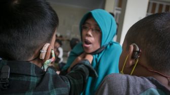 Guru mengajari siswa penyandang tuna rungu membaca Iqra dengan metode membaca gerak bibir saat mengikuti kegiatan Pesantren Kilat Ramadhan Tuna Rungu di SLB B Prawestri, Karanganyar, Jawa Tengah, Kamis (7/4/2022).  ANTARA FOTO/Mohammad Ayudha
