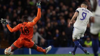 Striker Real Madrid asal Prancis Karim Benzema mencetak gol ketiganya melewati kiper Chelsea Edouard Mendy (kiri) pada pertandingan sepak bola leg pertama perempat final Liga Champions UEFA antara Chelsea melawan Real Madrid di stadion Stamford Bridge, Kamis (7/4) dini hari WIB
Adrian DENNIS / AFP
