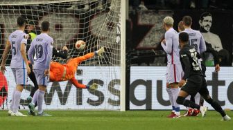 Gelandang Frankfurt Ansgar Knauff (kanan) mencetak gol pembuka melewati kiper  Barcelona Marc-Andre ter Stegen Saat pertandingan leg pertama perempat final Liga Europa UEFA antara Eintracht Frankfurt dengan FC Barcelona di Frankfurt, Jerman, Kamis (7/4/2022). [Daniel ROLAND / AFP]

